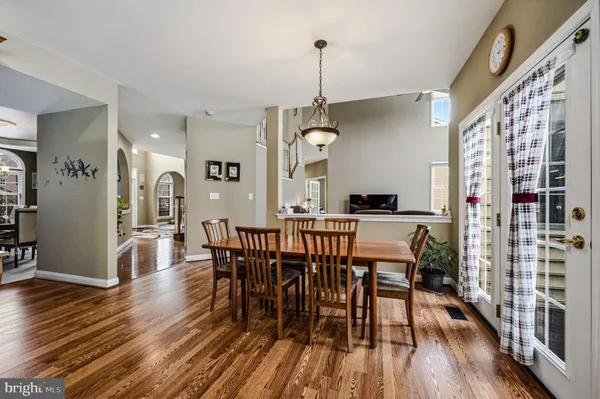 a kitchen with stainless steel appliances granite countertop a stove top oven a sink dishwasher a refrigerator and cabinets with wooden floor