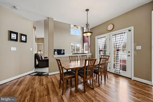 a kitchen with stainless steel appliances granite countertop a table chairs refrigerator and a stove