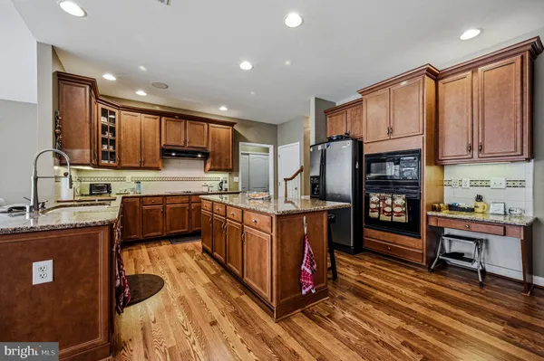 a kitchen with granite countertop a table chairs stove microwave and cabinets