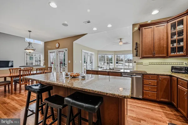 a kitchen with granite countertop a sink and a wooden floor