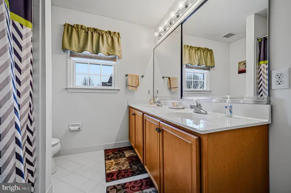 a spacious bedroom with a bed a window and a flat screen television