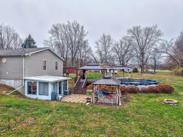 a backyard of a house with wooden fence and a tree