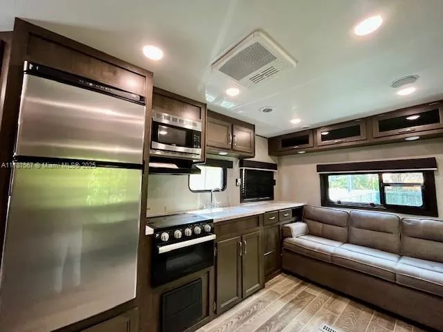 a kitchen with stainless steel appliances granite countertop a refrigerator and a stove top oven