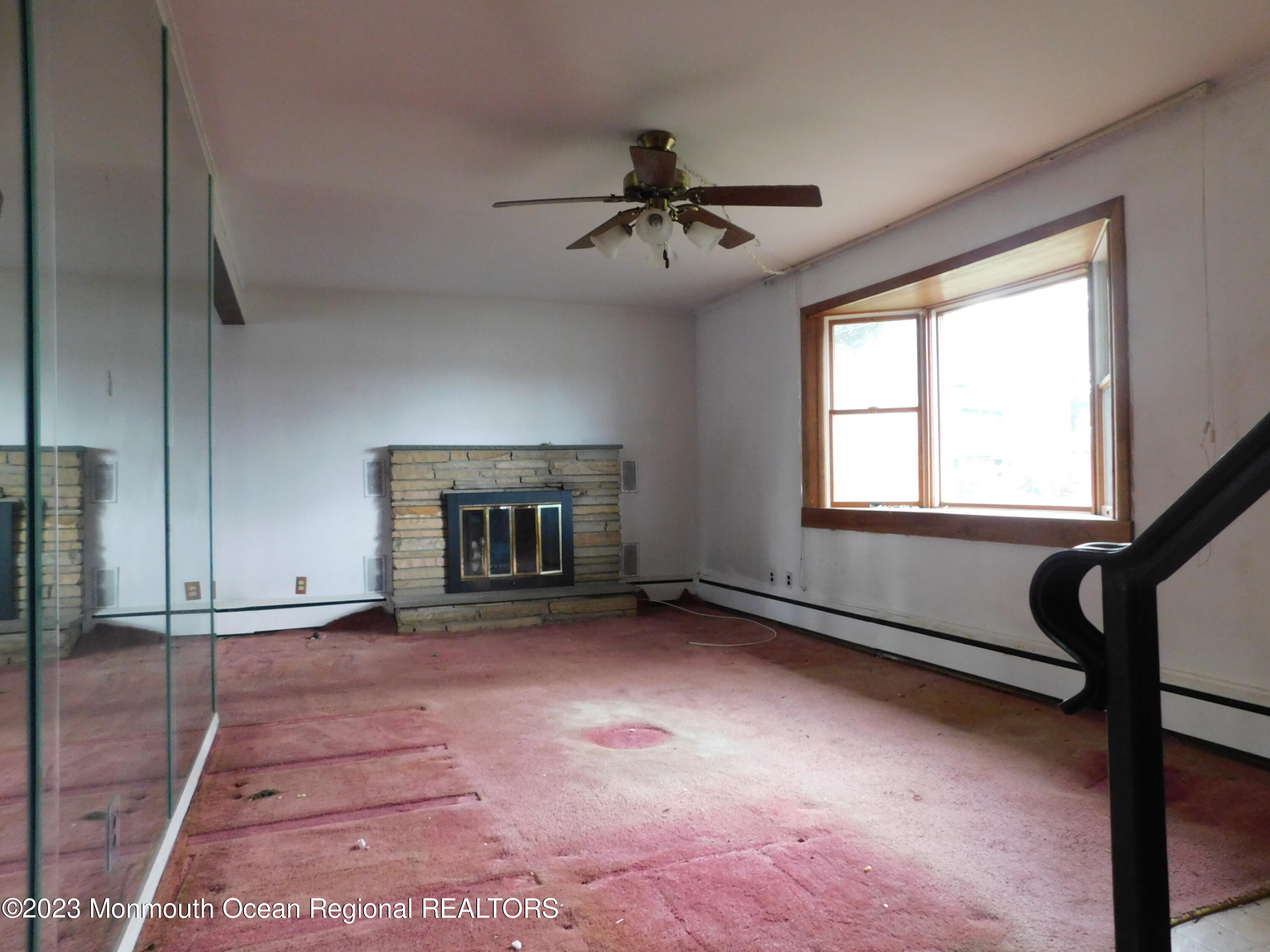 660 Pine Meadow Road Brick, NJ 08724 - Photo 7 of 67 a view of an empty room with a fireplace and a window