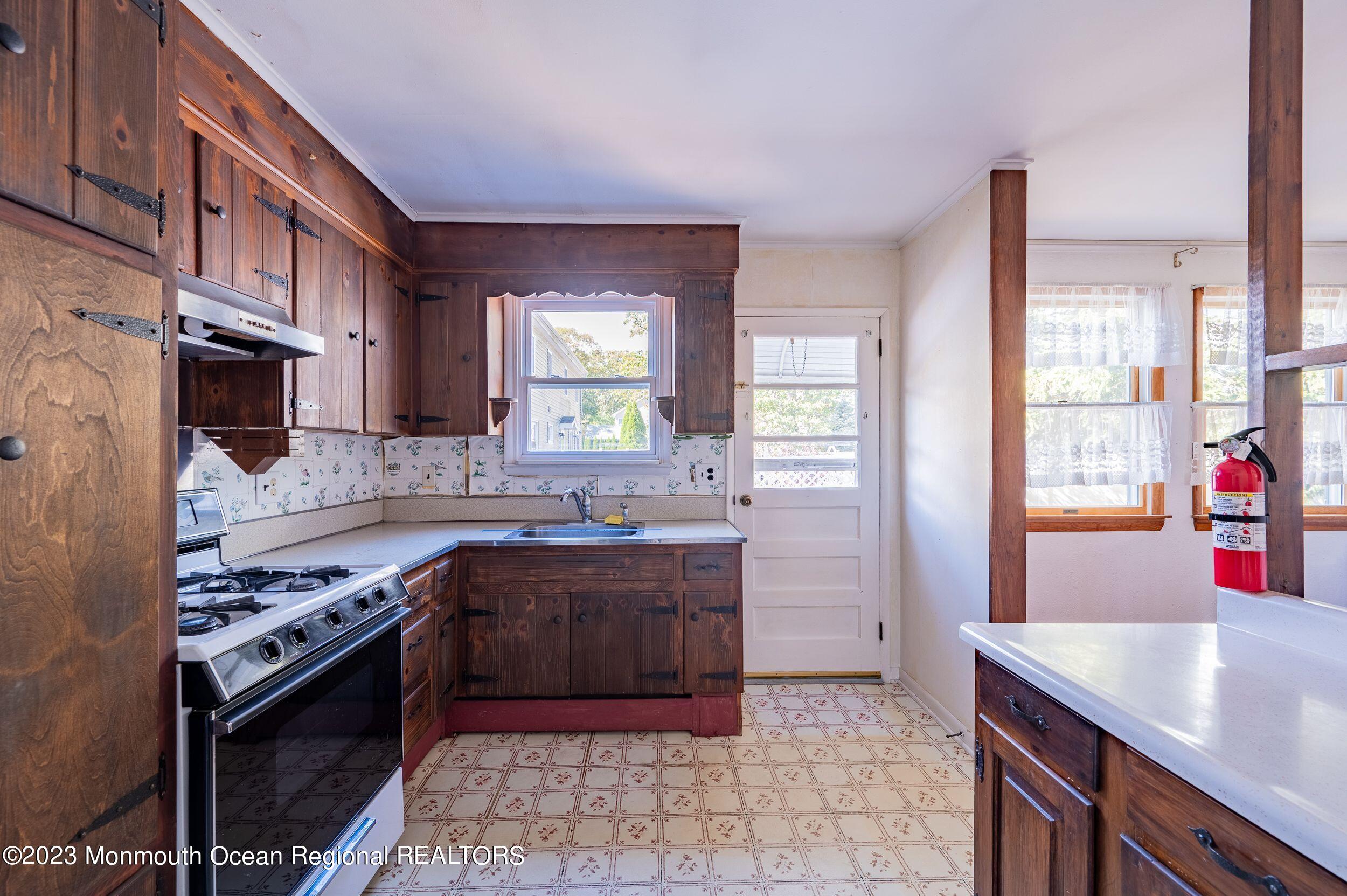 660 Pine Meadow Road Brick, NJ 08724 - Photo 10 of 67 a kitchen with kitchen island granite countertop a sink stove and cabinets