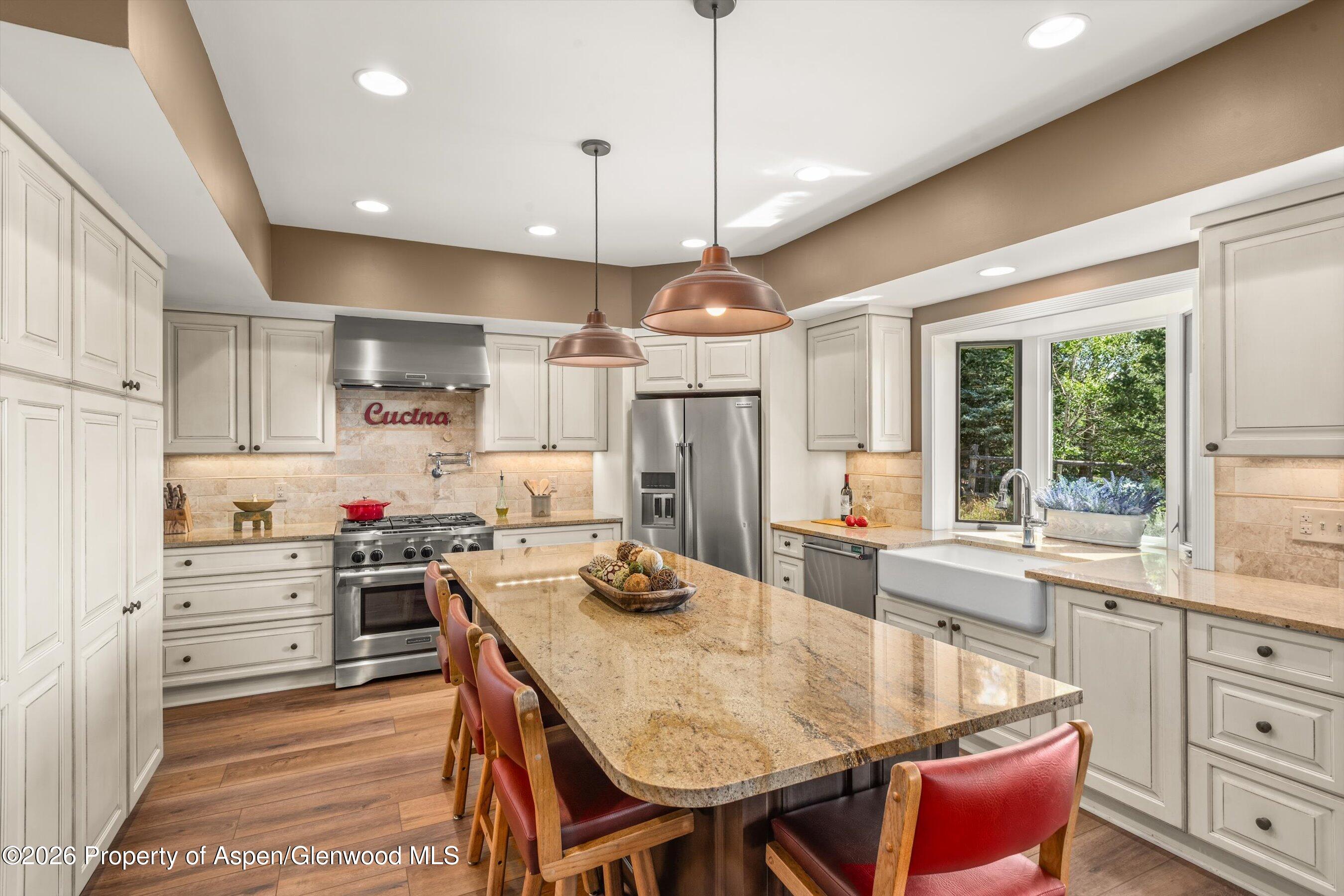 614 Escalante Road Carbondale, CO 81623 - Photo 1 of 46 a kitchen with kitchen island a stove a table and chairs in it