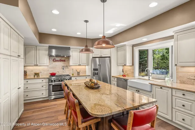 a kitchen with kitchen island a stove a table and chairs in it