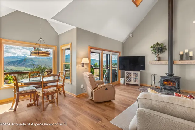 a living room with furniture a flat screen tv and a large window
