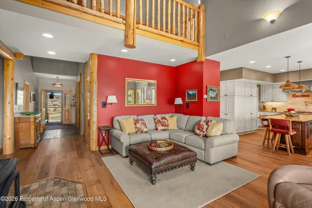 a living room with furniture kitchen view and a large window