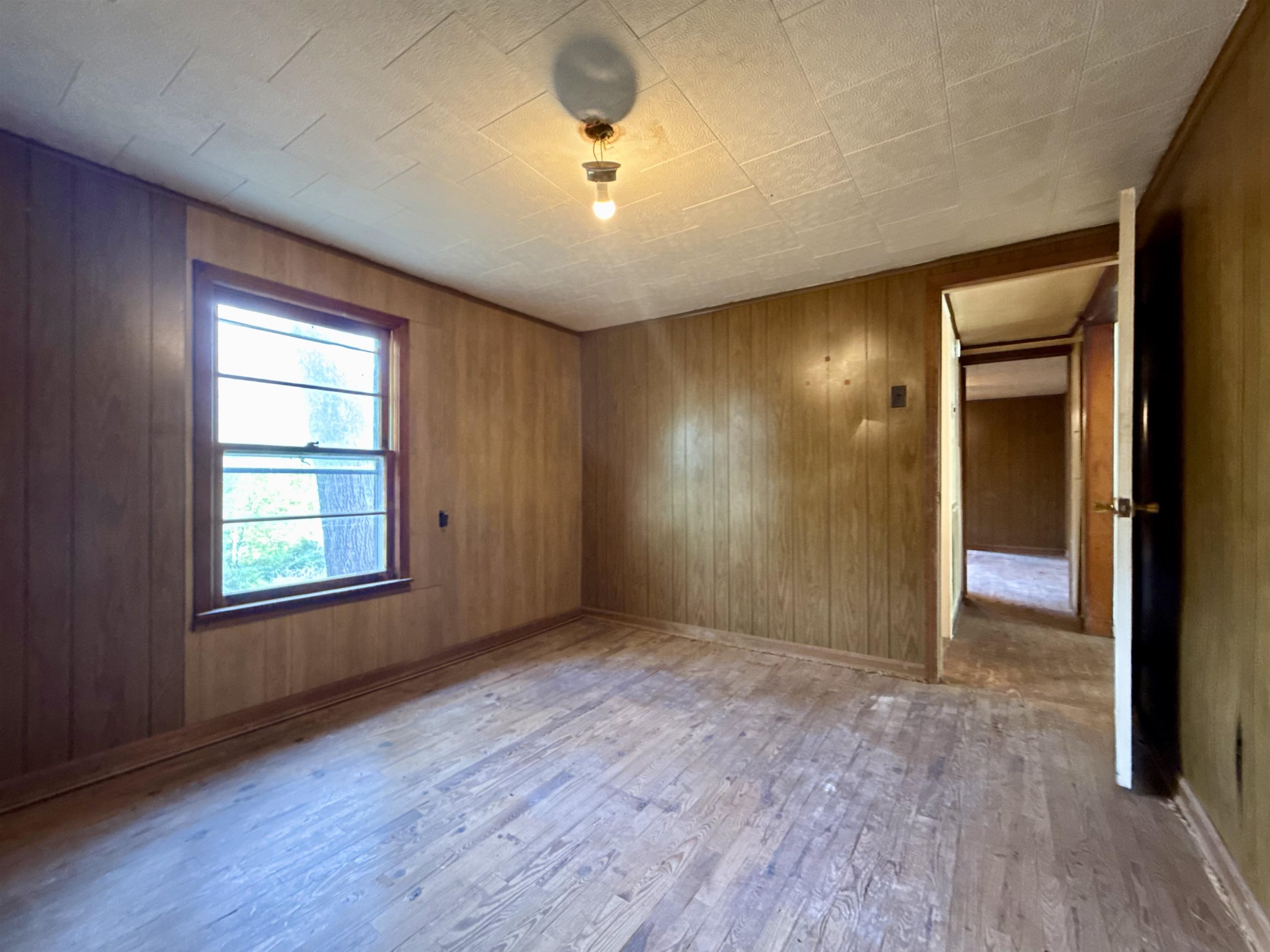 845 Needham Road Drummonds, TN 38023 - Photo 12 of 22 Spare room with wood walls and light wood-type flooring