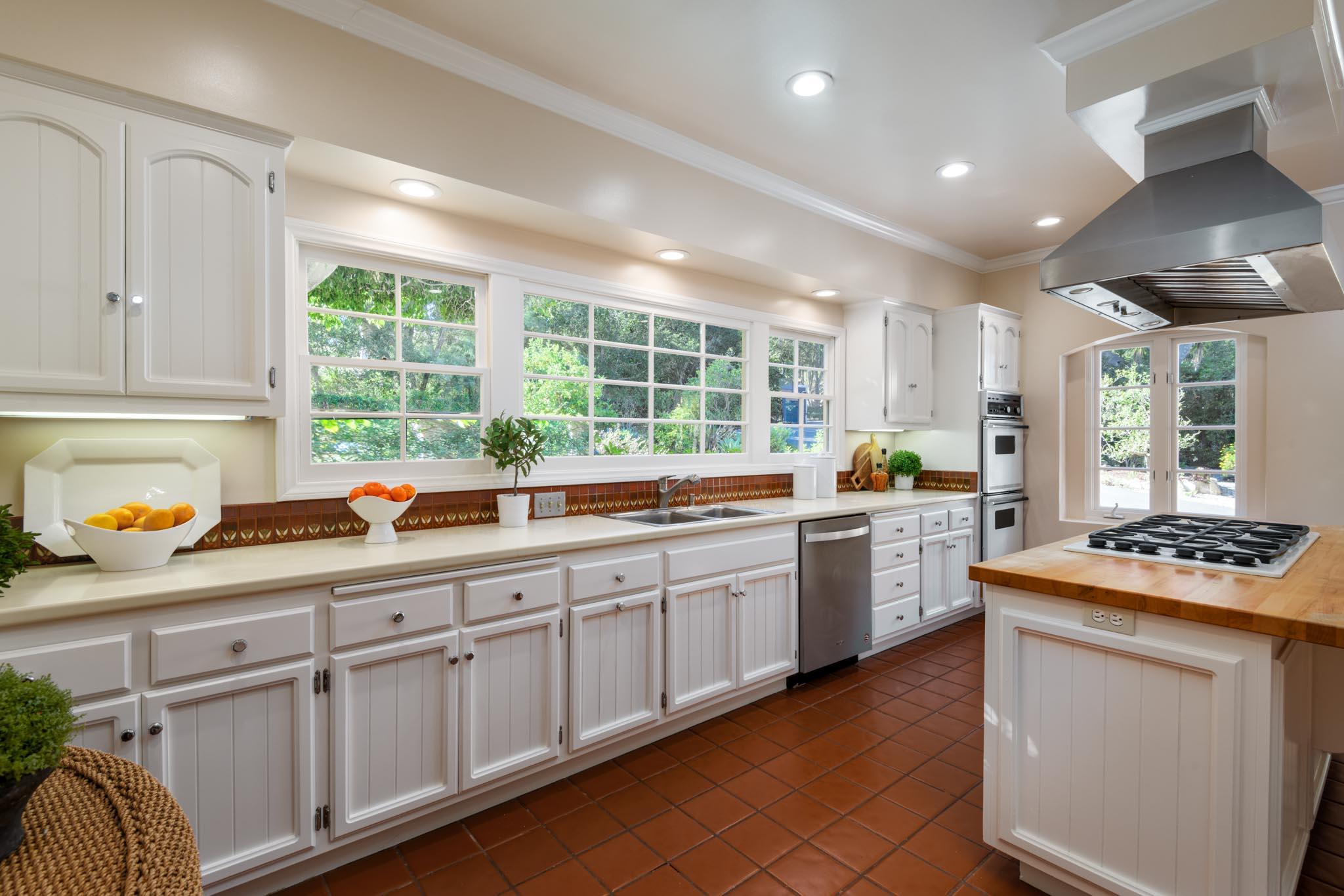 937 Arcady Road Santa Barbara, CA 93108 - Photo 7 of 31 a kitchen with kitchen island granite countertop white cabinets and white appliances