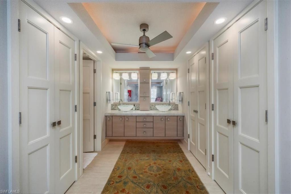 107 Clubhouse Lane, Unit 391 Naples, FL 34105 - Photo 18 of 37 a bathroom with a double vanity sink a mirror and a shower