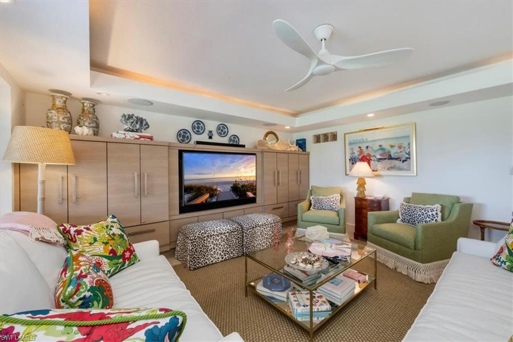 107 Clubhouse Lane, Unit 391 Naples, FL 34105 - Photo 2 of 37 a living room with furniture and a flat screen tv