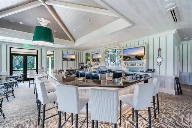 a dining hall with stainless steel appliances kitchen island granite countertop a table and chairs