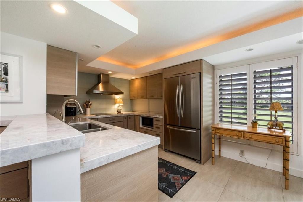 107 Clubhouse Lane, Unit 391 Naples, FL 34105 - Photo 8 of 37 a kitchen with granite countertop a refrigerator and a sink
