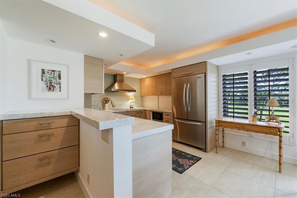 107 Clubhouse Lane, Unit 391 Naples, FL 34105 - Photo 9 of 37 a kitchen with a refrigerator and a sink