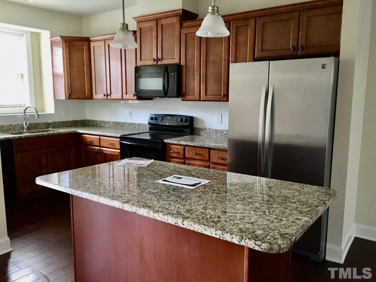 3950 Amelia Park Drive Raleigh, NC 27606 - Photo 6 of 20 a kitchen with stainless steel appliances granite countertop a sink a stove and refrigerator
