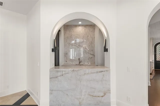 a bed sitting in a spacious bedroom next to a window