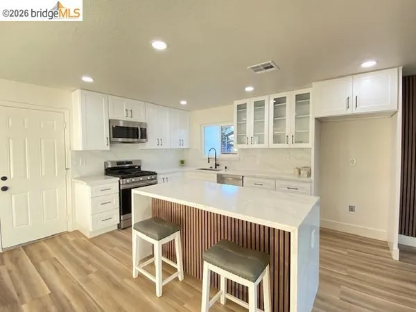 a large kitchen with a large window and stainless steel appliances
