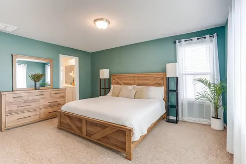 a bedroom with a bed lamp and a large window