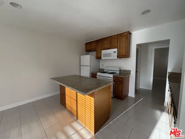 a kitchen with stainless steel appliances granite countertop a stove a refrigerator and a sink