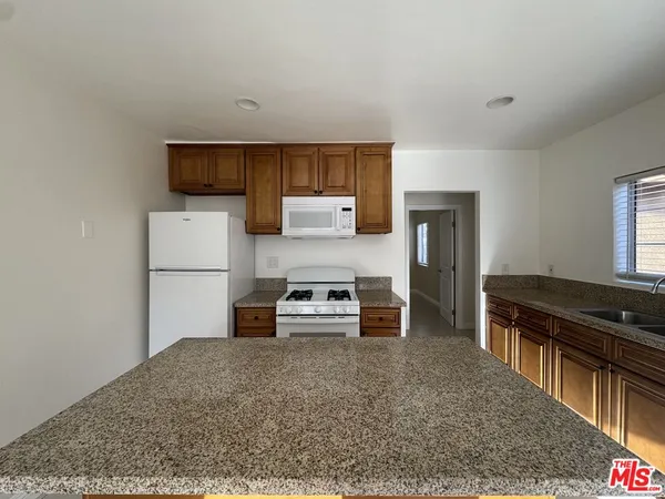 a kitchen with stainless steel appliances granite countertop a refrigerator stove and oven