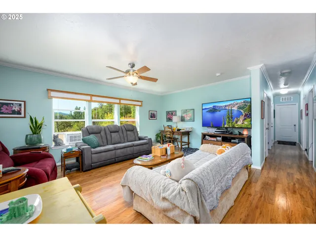 a living room with furniture a flat screen tv and a large window