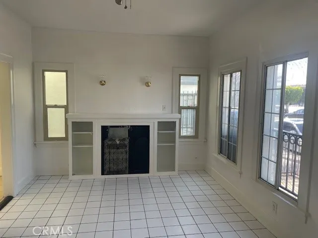 a view of an empty room with window and cabinet