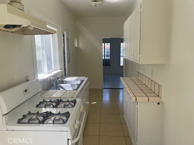 1738 East 4th Street, Unit 1 Long Beach, CA 90802 - Photo 15 of 23 a kitchen with a sink stove and cabinets