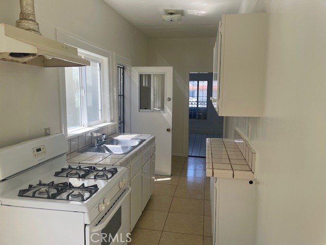 1738 East 4th Street, Unit 1 Long Beach, CA 90802 - Photo 17 of 23 a kitchen with a sink stove and cabinets