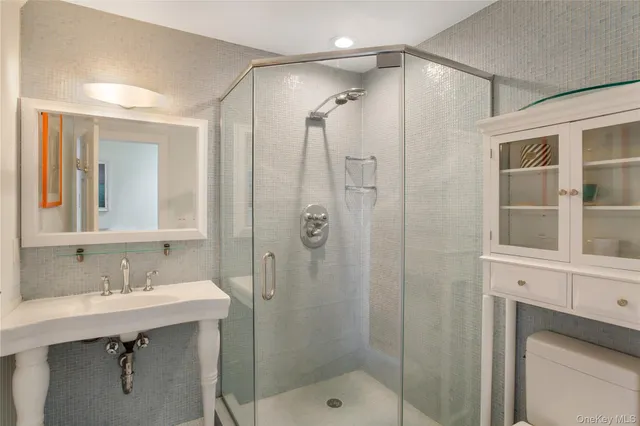 a bathroom with a shower sink vanity and mirror