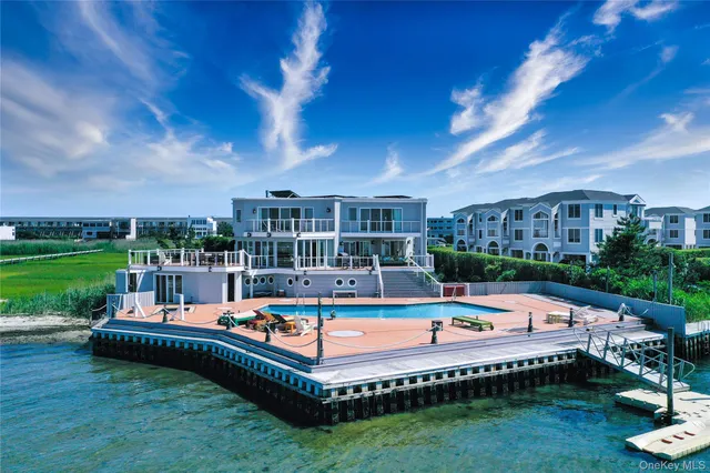 a view of a swimming pool and lounge chairs in back yard of the house