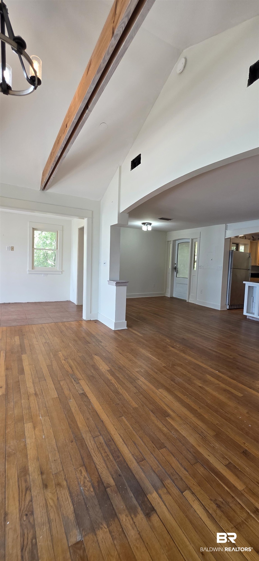 544 Windmill Ridge Road Gulf Shores, AL 36542 - Photo 13 of 50 Unfurnished living room with dark wood-style floors, a chandelier, high vaulted ceiling, and beamed ceiling