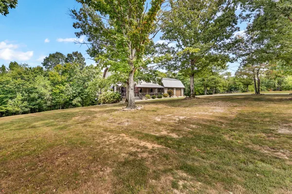 a kitchen with stainless steel appliances granite countertop a stove a refrigerator and a dining table with wooden floors