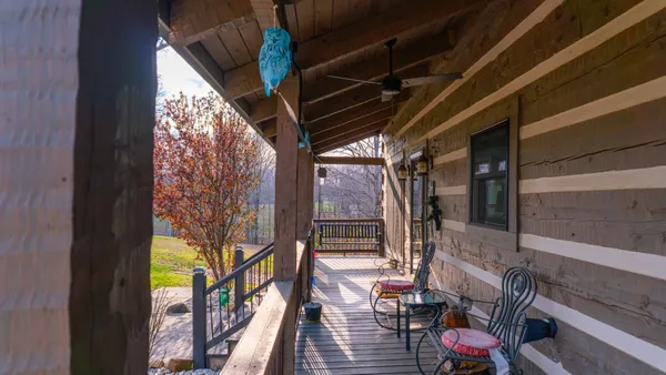 a living room with furniture floor to ceiling window and wooden floor