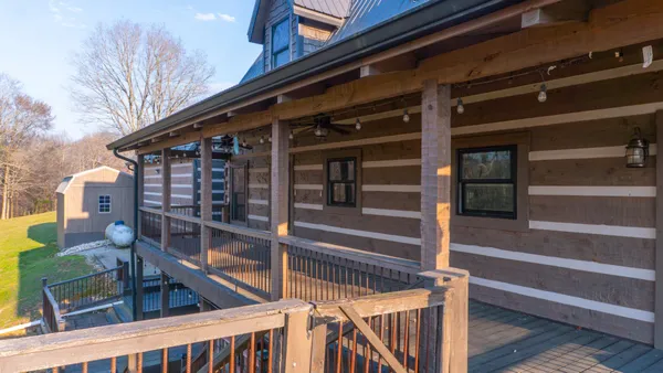 a view of a hallway with wooden floor and a bathroom