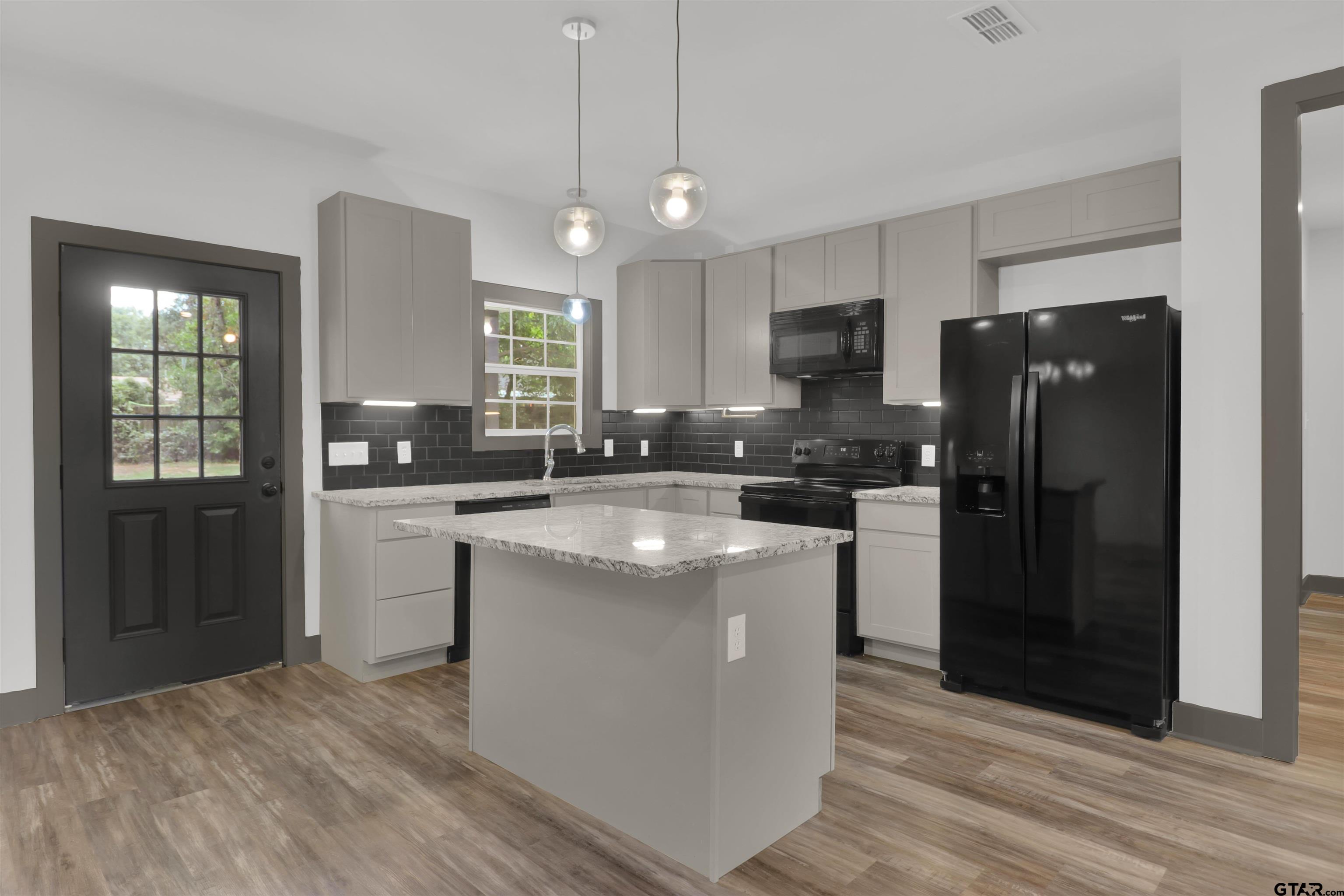 220 Sherman Street Rusk, TX 75785 - Photo 12 of 33 a kitchen with stainless steel appliances granite countertop a refrigerator a sink a stove a microwave and island
