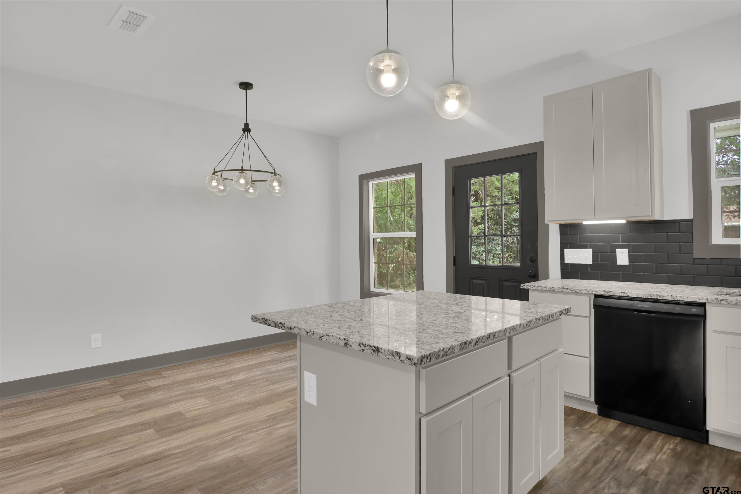 220 Sherman Street Rusk, TX 75785 - Photo 16 of 33 a kitchen with a sink chandelier and refrigerator