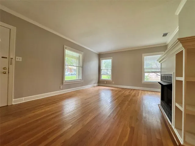 a view of a kitchen with kitchen island a sink wooden floor and a large window