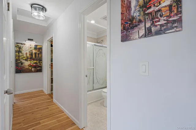 a view of a hallway with wooden floor and closet