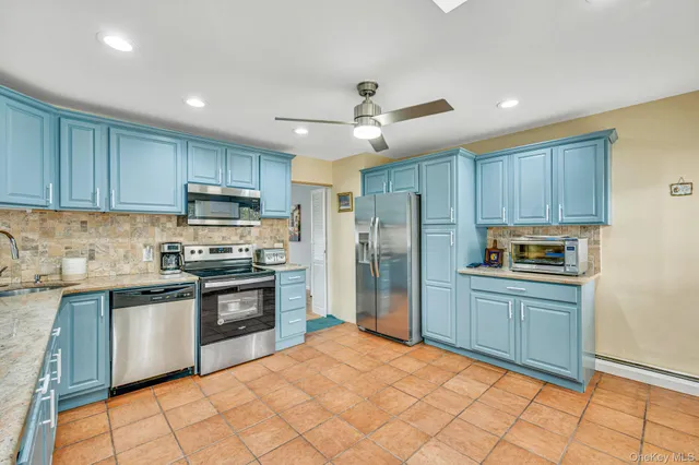 a kitchen with stainless steel appliances granite countertop a stove top oven a refrigerator and a sink