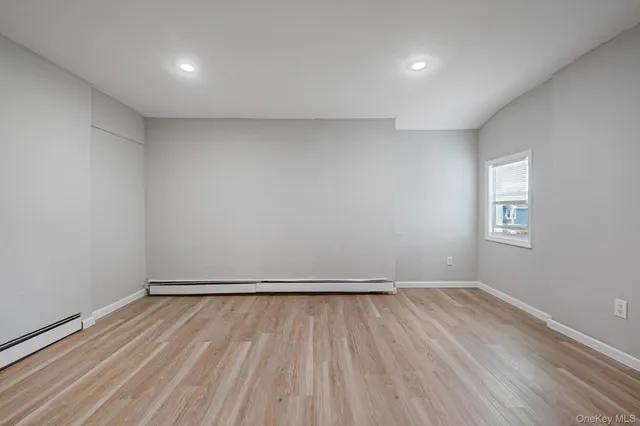 a view of room with window and wooden floor