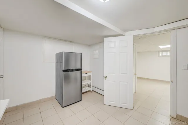 a view of a refrigerator in kitchen and white cabinets