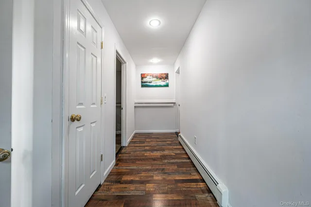 a view of a hallway with wooden floor
