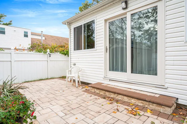 a white house with a large window and garden space