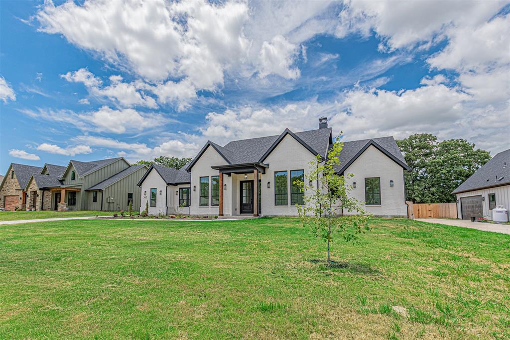 360 Dalton Road Canton, TX 75103 - Photo 1 of 33 Modern farmhouse style residence featuring a light-colored exterior, dark-framed windows, a dark roof, a prominent front entry, and a spacious front lawn