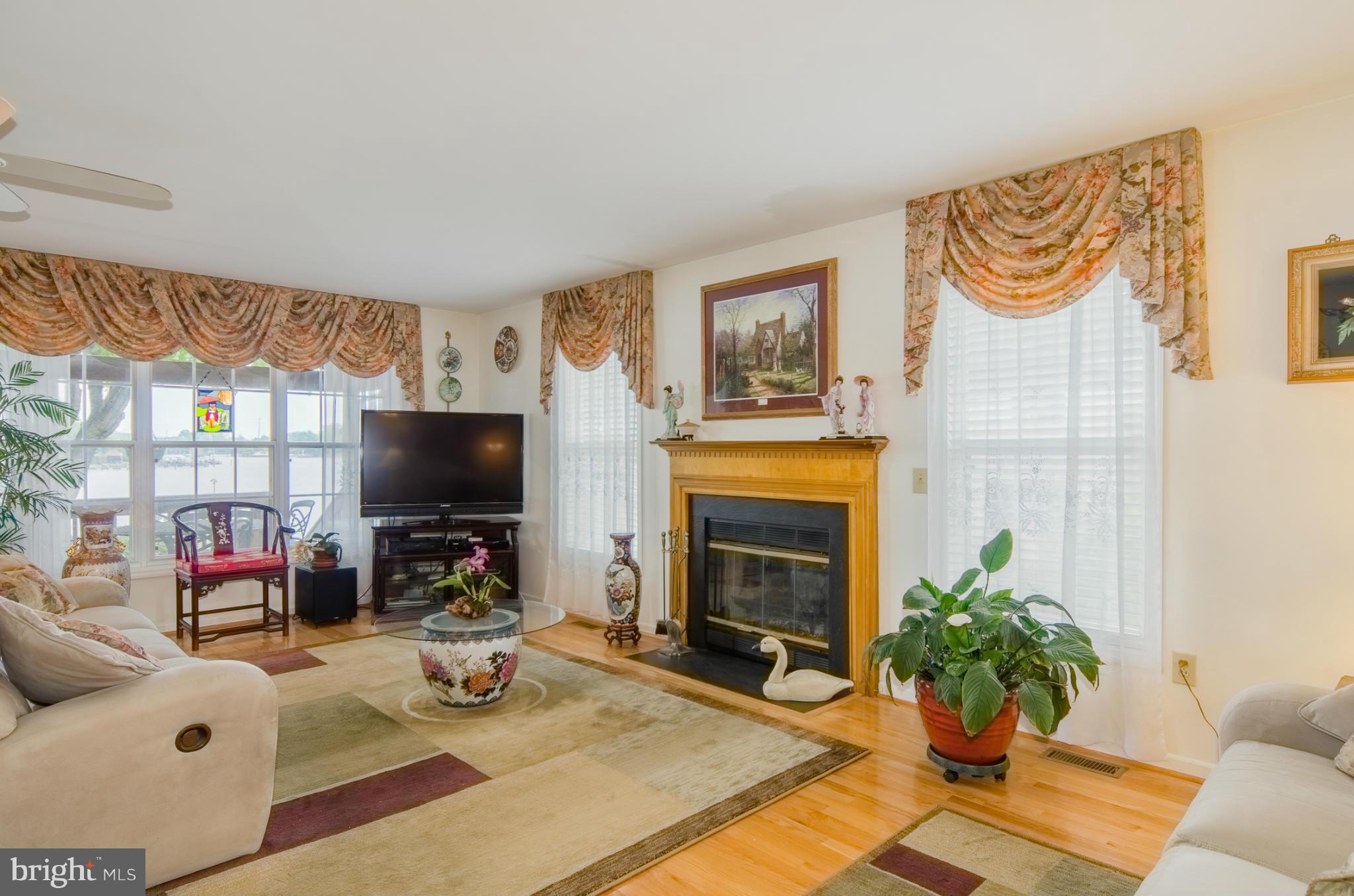 8620 Sandy Plains Road Baltimore, MD 21222 - Photo 3 of 30 a living room with furniture a fireplace and a flat screen tv