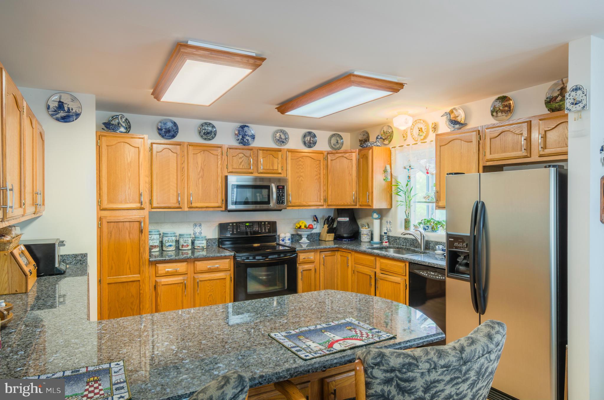 8620 Sandy Plains Road Baltimore, MD 21222 - Photo 9 of 30 a kitchen with stainless steel appliances granite countertop a refrigerator a stove top oven a sink a dining table and chairs with the wooden floor