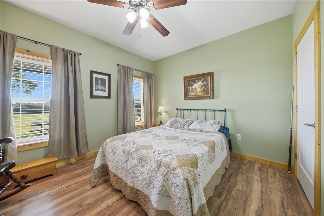 126 South Berlin Road Brenham, TX 77833 - Photo 21 of 30 a bedroom with a bed and wooden floor