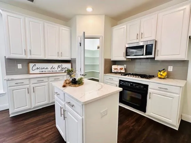 a kitchen with white cabinets and white appliances